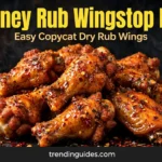 Crispy hot honey rubbed chicken wings piled on a dark board