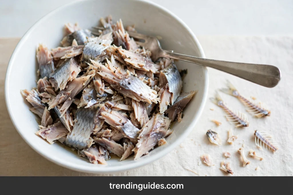 Flaked smoked herring in a bowl with a fork