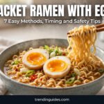 Steaming bowl of packet ramen with a jammy soft-boiled egg and chopsticks lifting noodles